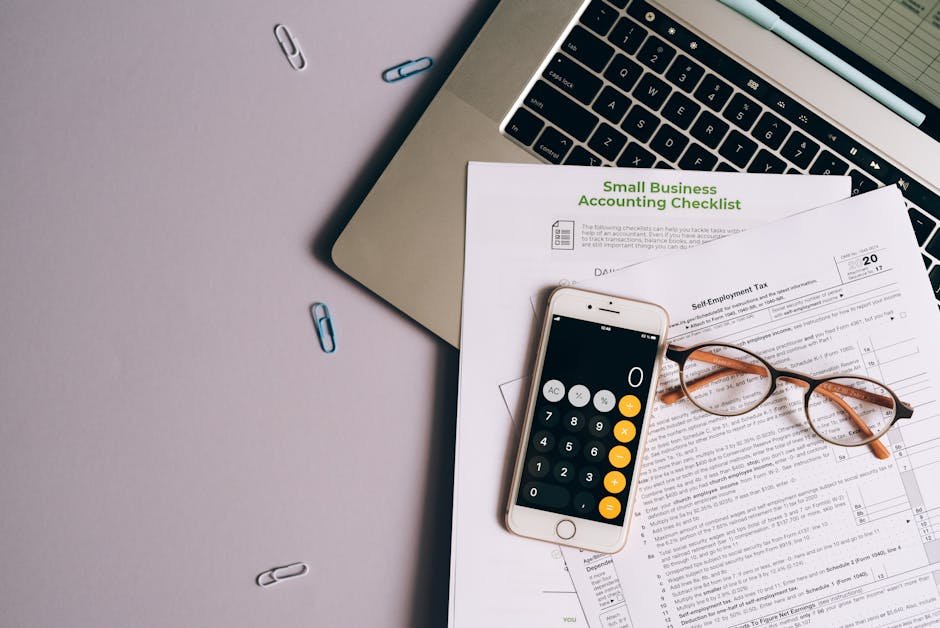 Phone, documents, and laptop on a desk — accounts and subscriptions to cancel after someone dies