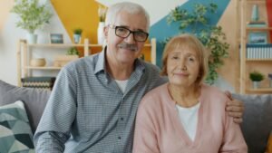 An elderly couple smiling together at home, representing the peace of mind that comes from organized medication management and family caregiving
