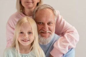 Three generations of a family smiling together — the sandwich generation caring for parents and kids